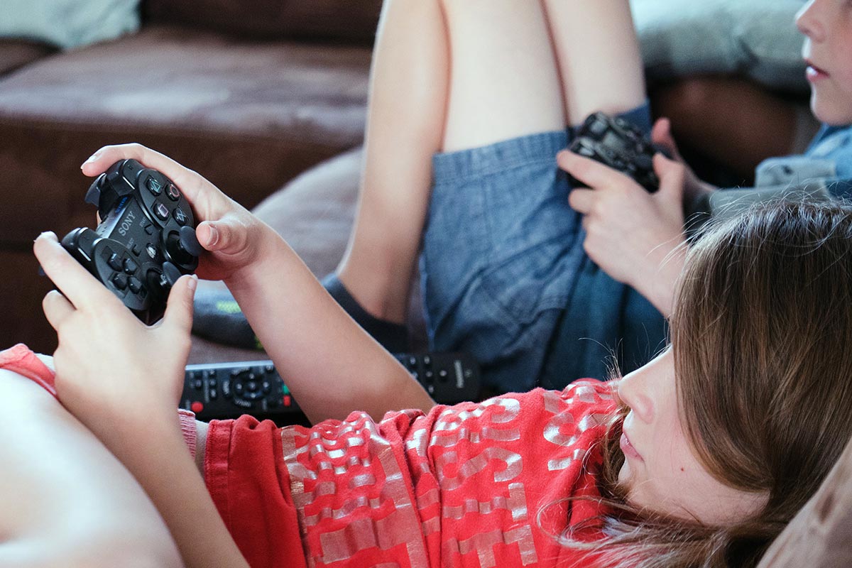 Ragazzi giocano sul divano con la Play Station