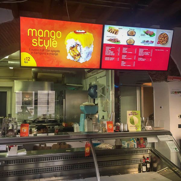 Due monitor display in 4K da 49 pollici di Samsung Smart Signage con staffaggio a soffitto espongono menu, prodotti e prezzi