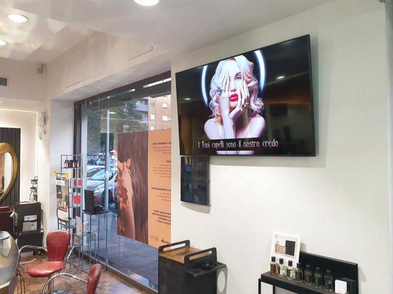 Display Samsung Smart Signage monitor tv installato all'interno del salone parrucchiere uomo donna
