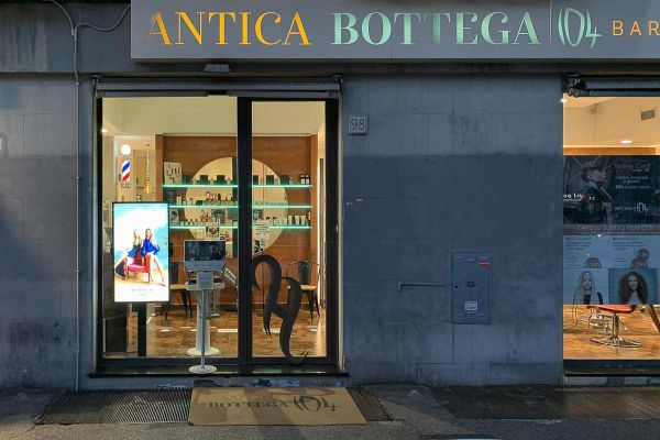 Samsung Display Signage nella vetrina e all'interno del parrucchiere e barberia Antica Bottega a Roma