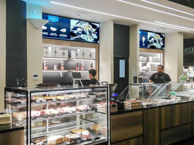 Videowall Samsung Smart Signage con menu prodotti installati a parete all'interno del bar caffetteria