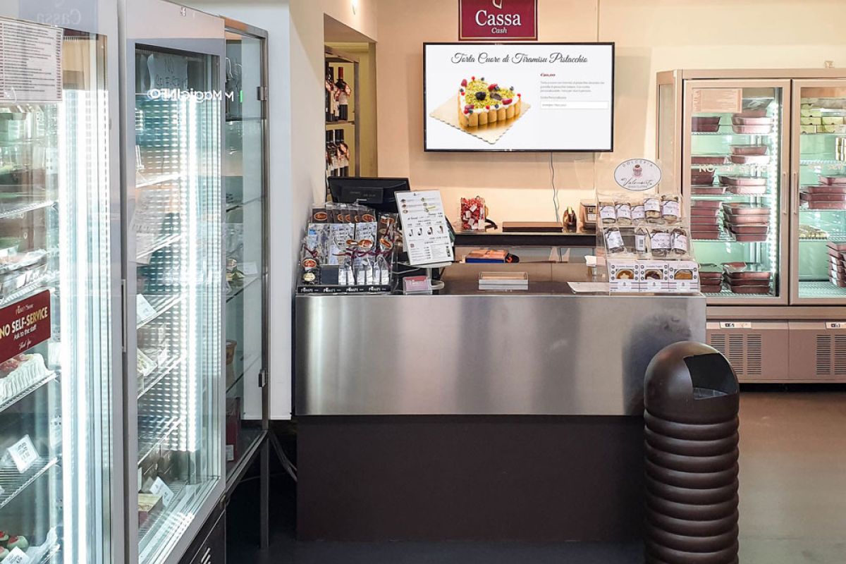 Samsung display Smart Signage installato a parete dietro in bancone della pasticceria