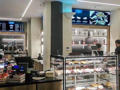 Videowall Samsung Smart Signage con menu prodotti installati a parete all'interno del bar caffetteria