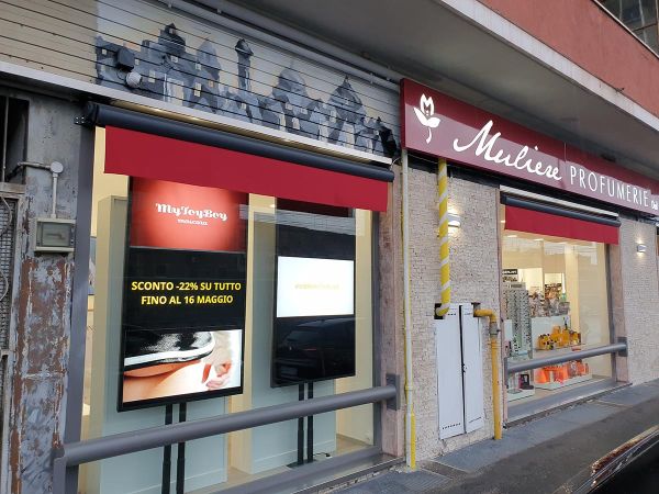 Due display smart signage da 75 pollici installati in verticale nella vetrina di una profumeria