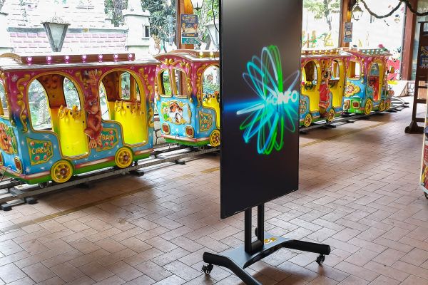 Monitor Display Samsung Digital Signage da 65 pollici 4K installato su supporto mobile all'interno del parco divertimenti