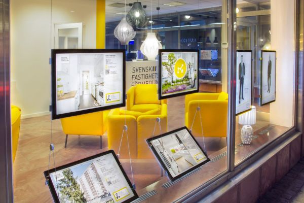 Monitor business display mostrano annunci nelle vetrine di un'agenzia immobiliare