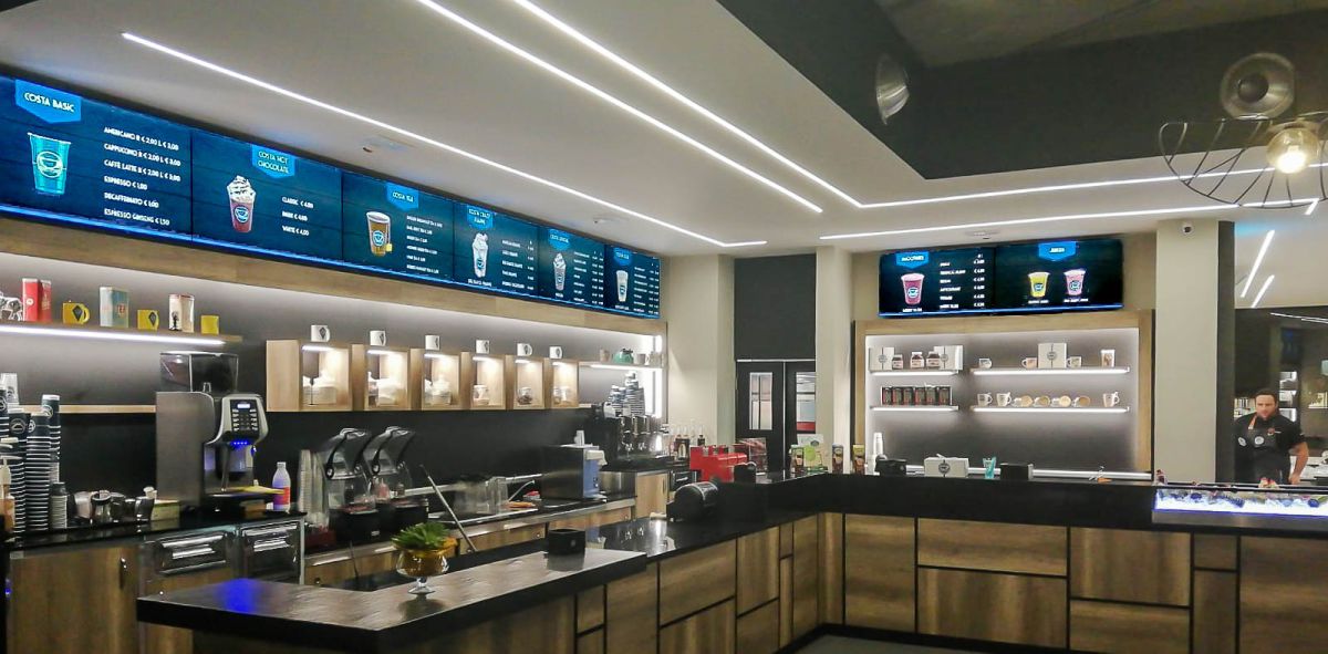 Videowall Samsung Smart Signage con menu prodotti installati a parete all'interno del bar caffetteria