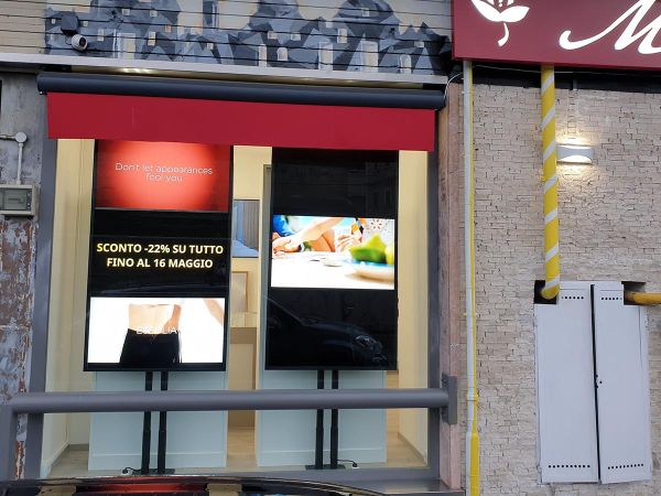 Due display smart signage da 75 pollici installati in verticale nella vetrina di una profumeria