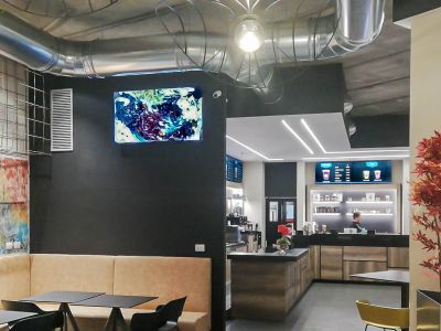 Videowall Samsung Smart Signage con menu prodotti installati a parete all'interno del bar caffetteria