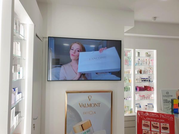 Un display smart signage da 65 pollici installato in orizzontale all'interno di una profumeria