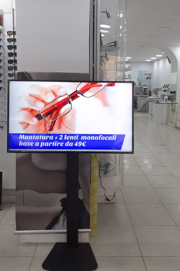 display signage su piantana all'interno e nella vetrina di un negozio di ottica