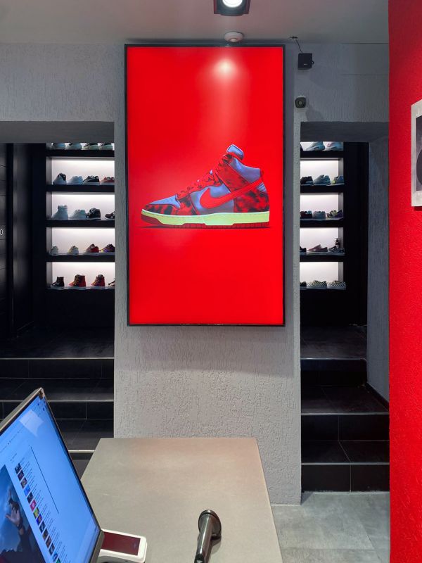 Monitor luminoso display smart signage di Samsung all'interno di un negozio di scarpe sportive