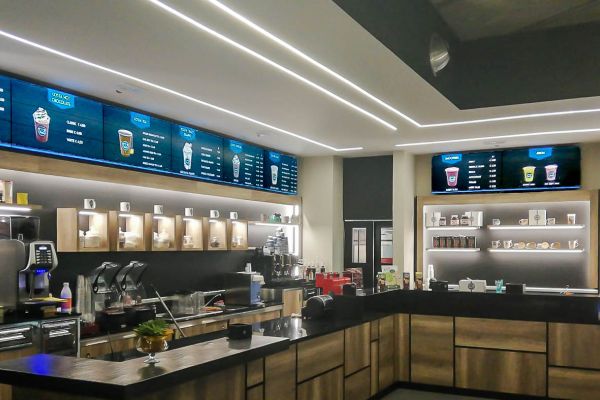 Videowall Samsung Smart Signage con menu prodotti installati a parete all'interno del bar caffetteria