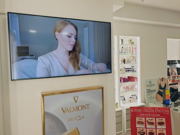 Un display smart signage da 65 pollici installato in orizzontale all'interno di una profumeria